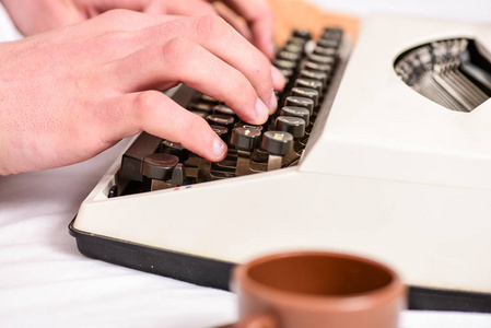 写常规。复古打字机的概念。手打字复古书写机。老打字机和作者手。男性手类型的故事或报告使用白色复古打字机设备关闭