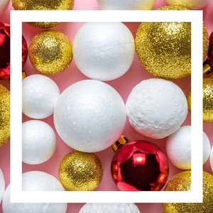 金色和白色闪光球装饰与红色圣诞宝在粉红色背景。 新年最小概念。 快关门。