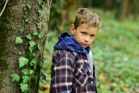 感觉如此无望。悲伤的男孩。带着悲伤的脸的小男孩。一个孩子一个人在树林里。寂寞和不快乐
