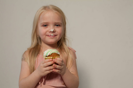 小女孩在手拿着一个甜蜜的纸杯蛋糕蛋糕