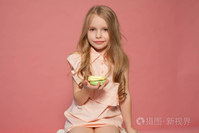 小女孩在手拿着一个甜蜜的纸杯蛋糕糖果