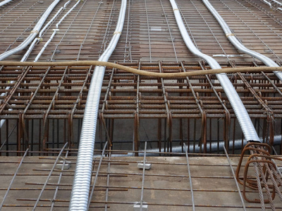 预应力电缆敷设在圆形管道中，并安装在施工现场板钢筋之间。