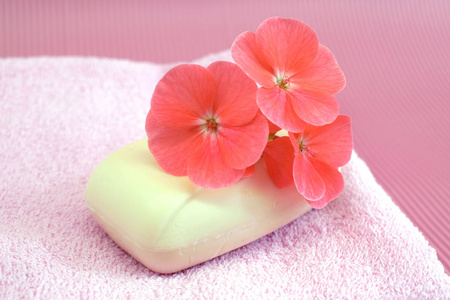 粉红色毛巾上的香花皂。