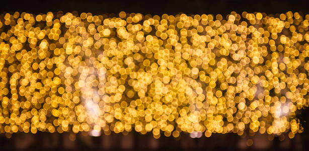 闪闪发光和闪闪发光的离焦闪烁温暖的金色光Bokeh照明户外墙壁装饰背景。 特殊节日节日设计装饰新年庆祝晚会。