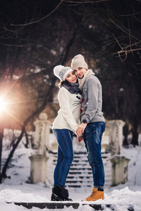 冬天穿毛衣的男人和女孩在公园里拥抱。冬季散步, 休息