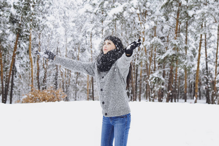 冬雪森林里穿毛衣的年轻美丽的黑发女孩