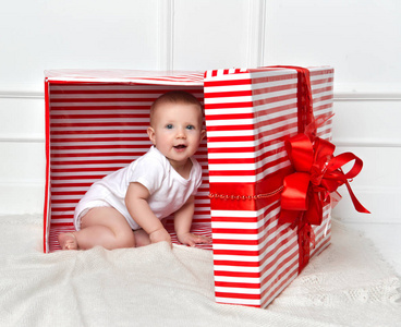 婴儿幼儿孩子坐在大红色礼物礼物盒庆祝圣诞节