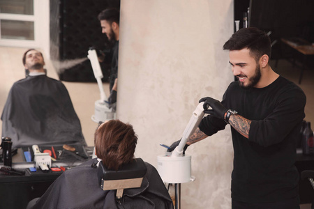 理发师和理发店的客户一起工作。 专业剃须服务