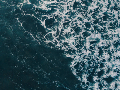 鸟瞰美丽的海浪从无人机。 海水海面蓝色的股票图像。 顶部看到绿松石波，清澈的水面纹理。 顶级景观，惊人的自然背景