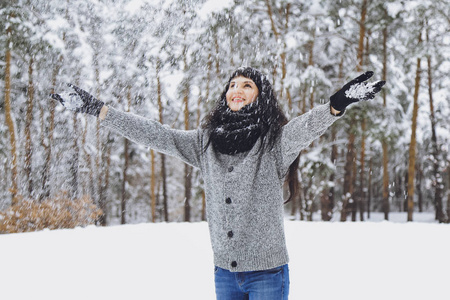 冬雪森林里穿毛衣的年轻美丽的黑发女孩