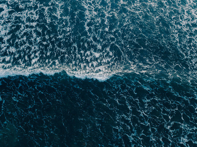 鸟瞰美丽的海浪从无人机。 海水海面蓝色的股票图像。 顶部看到绿松石波，清澈的水面纹理。 顶级景观，惊人的自然背景