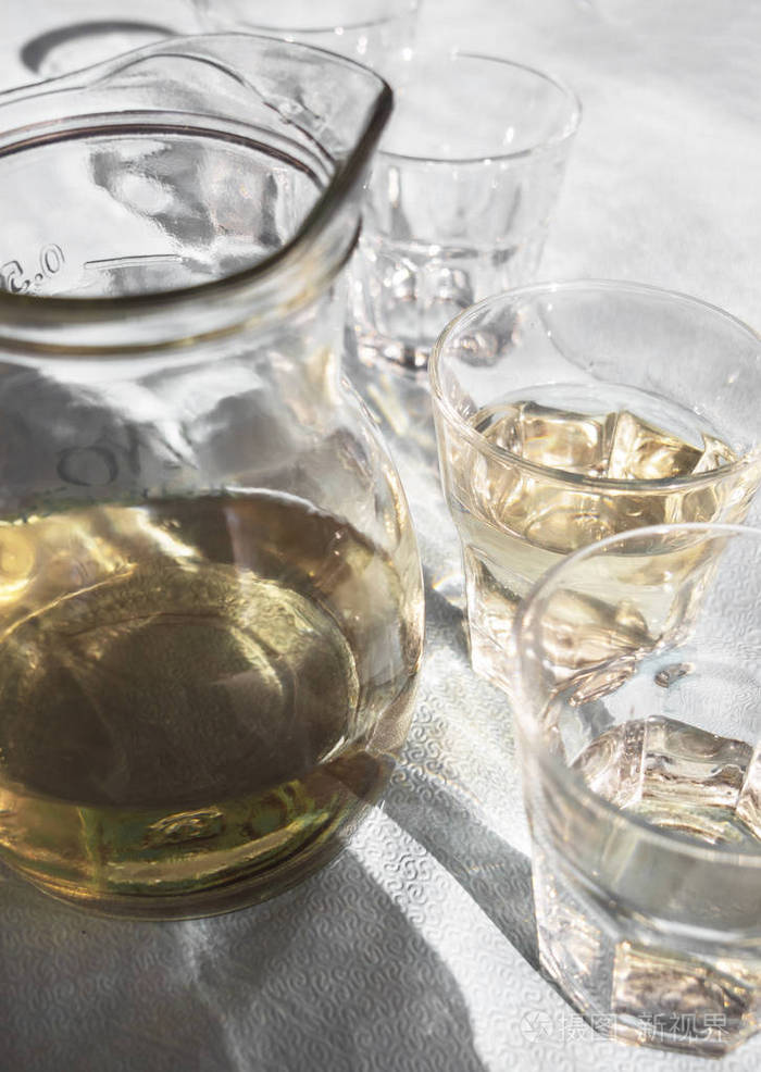 在阳光下的一家酒馆里,桌子上摆满了自制的希腊白葡萄酒,还有漂亮的