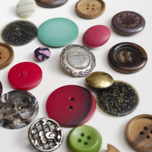 许多五颜六色的按钮白色木制桌子上的许多彩色纽扣,请关闭照片