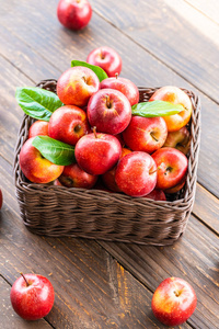 很多红苹果水果放在桌子上的棕色篮子里