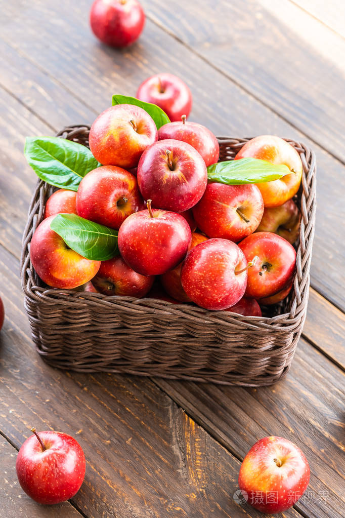 很多红苹果水果放在桌子上的棕色篮子里照片-正版商用图片16bul2-摄图