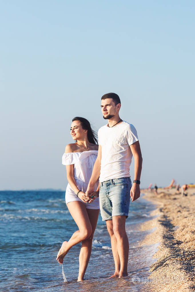 在海边摆姿势的年轻幸福夫妇
