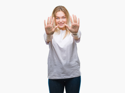 年轻的白种人女人在孤立的背景下，用十号手指显示和指着，同时微笑着自信和快乐。