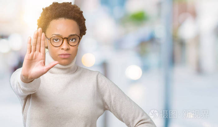 年轻美丽的非洲裔美国妇女戴着眼镜，在孤立的背景下，停止用手掌唱歌。 警告表情，脸上有负面和严肃的手势。