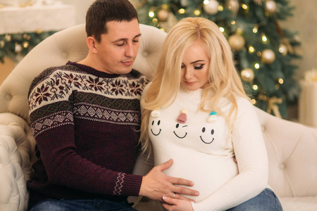 在圣诞假期, 宾至如归在美丽的针织毛衣。把时间在一起。孕妇