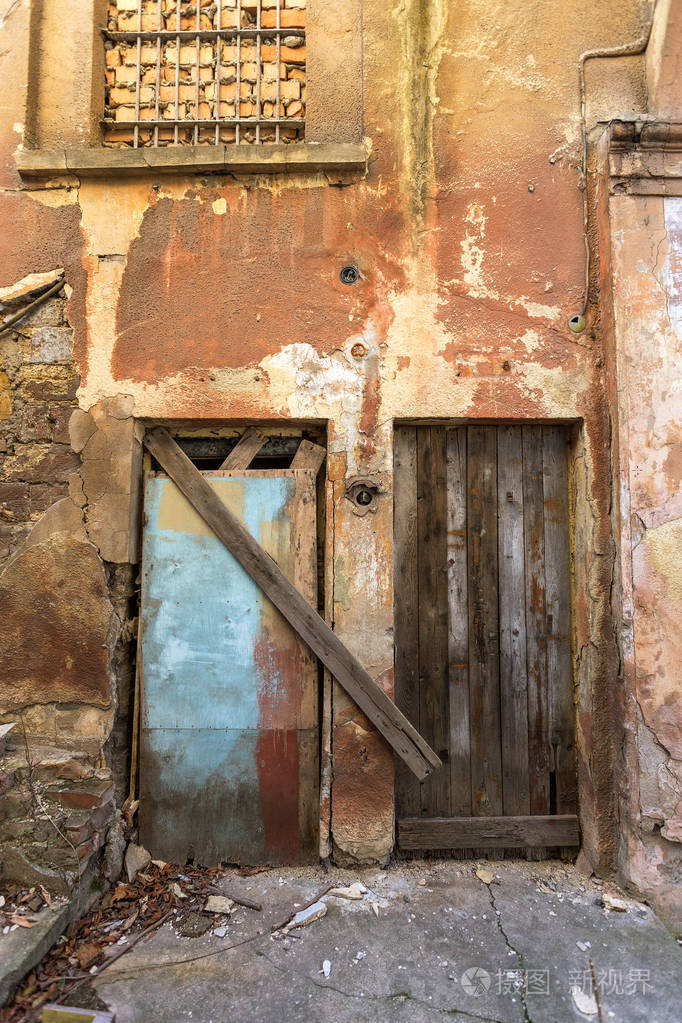 贫穷小区的旧木门古老的老式木头在一堵旧墙上销毁木门和老式栅栏生锈