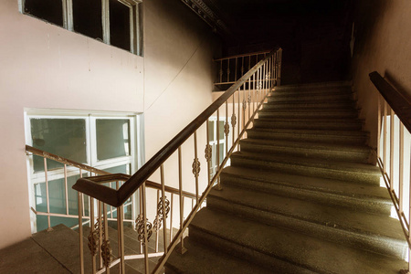 旧建筑的水泥石楼梯。 一座过时建筑地板之间的老式石楼梯。 在美国建设20世纪的时尚和技术