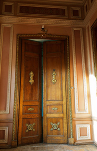 旧木门。 古老的古董木头在一堵旧墙上。 古老的装饰木门。 历史艺术风格的门面，精英昂贵的古董门。 木制背景旧前门复古元素