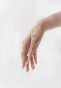 手上的水通过手指流动水滴从白色背景下分离下来美丽的长手指手上的皮肤护理