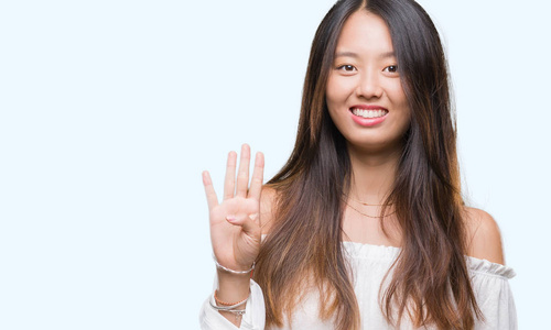 年轻的亚洲女人在孤立的背景下，用手指第四，同时微笑，自信和快乐。