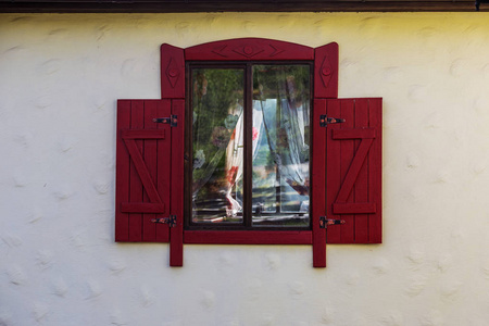一扇古色古香的木制窗户和木制百叶窗。 一个典型的带有木制百叶窗的农民住宅的老式门面