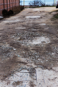 损坏的道路开裂沥青黑顶，有坑洞和补丁坏道路。 非常糟糕的柏油路有很大的洞。 道路建设中的可怕技术。 农村道路