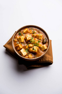 用煮好的鹰嘴豆加干酪加香料制成的奶油咖喱。 流行的北印度食谱。 盛在碗里或锅里。 选择性聚焦