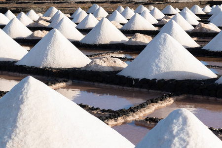 西班牙加那利群岛兰萨罗特市盐厂炼油厂盐矿的盐层勘探用成堆盐照片