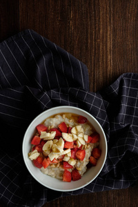 健康早餐燕麦片与香蕉草莓蜂蜜和松子。 复制空间
