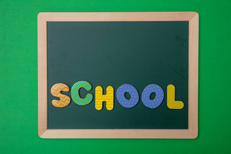 学校观念。 绿色粉笔与木框文字学校彩色字母绿色墙背景复印空间