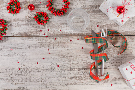 冬天的地方设置圣诞节和新年装饰在白色的木制桌子上。 圣诞晚餐的节日餐桌设置。 顶部视图，文本复制空间