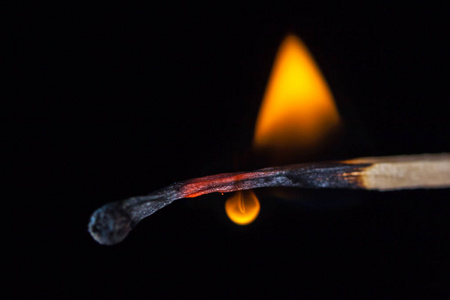 燃烧火柴棒在手上的黑色孤立的背景.照片