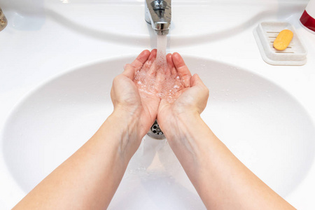 一个女人希望洗手池里有水。 预防和卫生理念。 有用的好习惯。