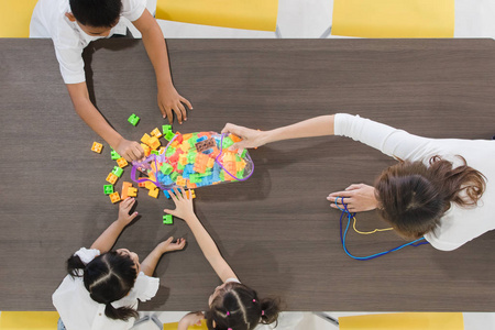 三个白人学生和物理老师一起修理无线电控制的玩具车模型.