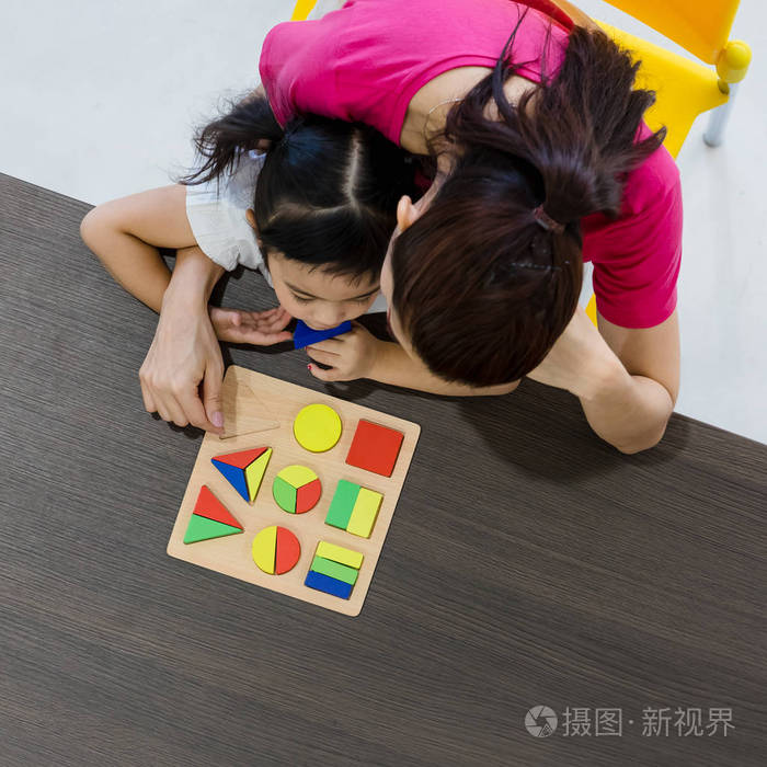 亚洲教师的平躺镜头与亚洲学生一起玩几何积木玩具概念为课堂