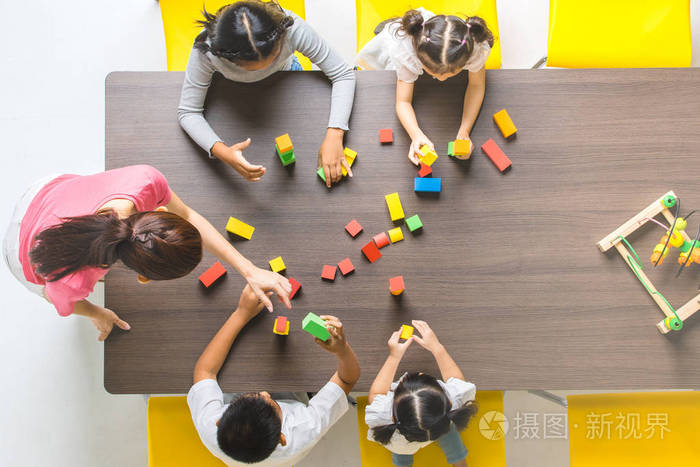 平躺镜头的亚洲教师玩彩色积木玩具与亚洲学生一起概念为课堂