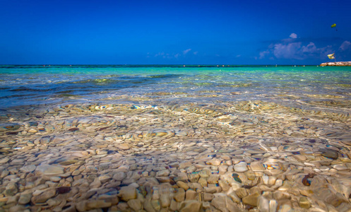 美丽的暴露在牙买加海滩与它的绿色和蓝色绿松石水，以及小岩石在水上。