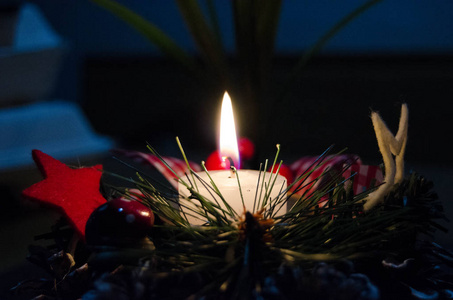 在雪地上燃烧蜡烛和圣诞装饰，木质背景优雅，低调，充满节日气氛