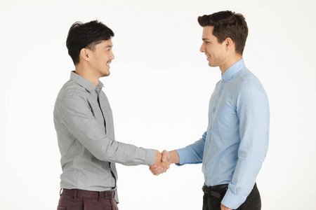 半长画室的肖像,两个年轻人在商务握手时摆出友好的姿势互相微笑,站在