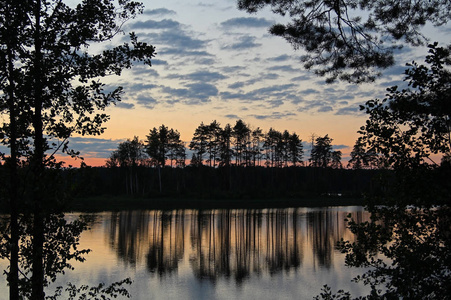傍晚的森林湖上映出了树木的轮廓和五彩缤纷的天空。 奇妙的风景。 不寻常和风景如画的场景。 美丽的世界。 俄罗斯。