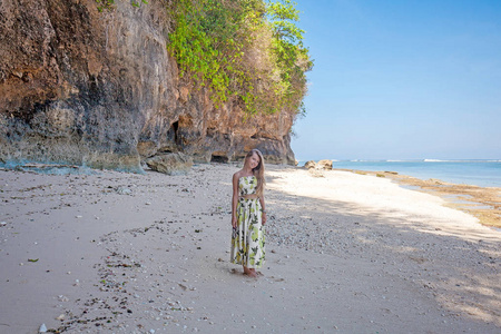 站在岩石和大海附近的海滩上的妇女