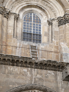 耶路撒冷老城基督教区的窗台上有一扇窗户和一个木制楼梯，这是圣墓庙正面的碎片