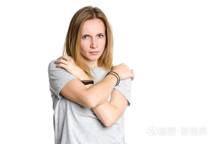 一个悲伤的女人的肖像她在恐惧中抱着自己孤立在白色的背景上