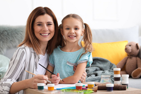 快乐的母亲和女儿在家画画