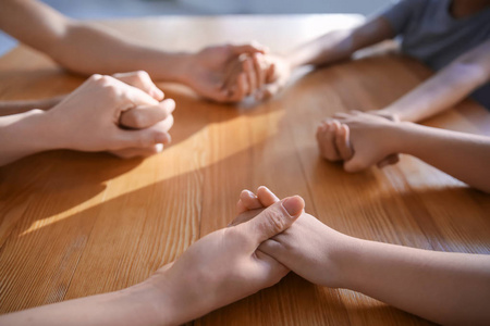 家人在木桌上祈祷,特写照片