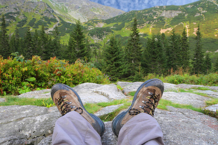 s feet in the shoes on the stones in the mountains